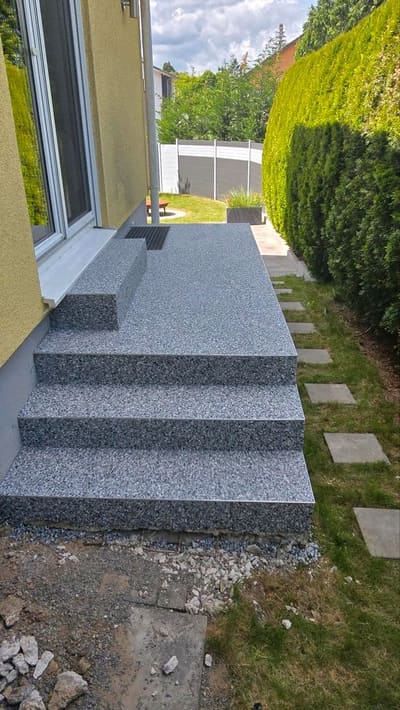Außentreppe mit Podest und Steinteppich neben einer Hecke – Treppensanierung außen von mf.steintechnik aus Kirchheim am Neckar