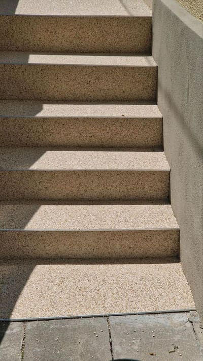 Treppe mit sandfarbenem Steinteppich und hellen Setzstufen – Treppensanierung von mf.steintechnik aus Kirchheim am Neckar