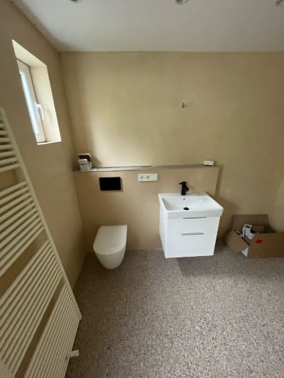 Badezimmer mit fugenlosen Mikrozement-Wänden in Sandton, Wand-WC und Waschtisch – fugenlose Badsanierung mit Mikrozement von mf.steintechnik aus Kirchheim am Neckar