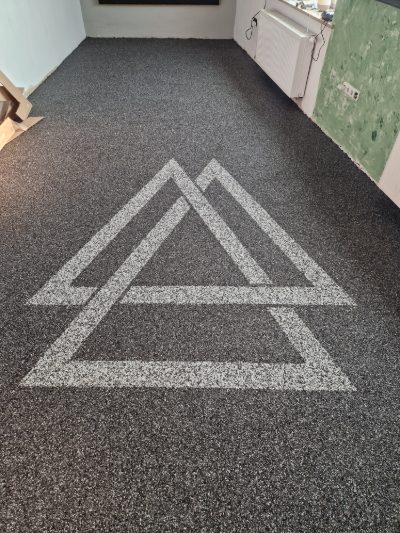 Großflächiger dunkler Steinteppich mit heller eingelegter Grafik als Intarsie – individueller Bodenbelag von mf.steintechnik aus Kirchheim am Neckar