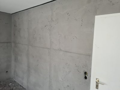 Wandfläche in Betonoptik mit sichtbarem Plattenraster neben einer weißen Zimmertür – Betonoptik von mf.steintechnik aus Kirchheim am Neckar