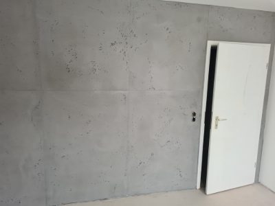Wand in Betonoptik mit weißer Zimmertür und sauberem Anschluss an die Zarge – Betonoptik von mf.steintechnik aus Kirchheim am Neckar